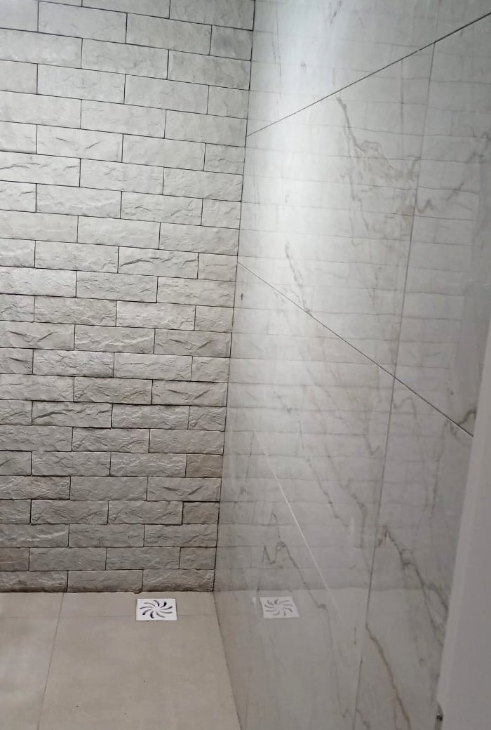 Parede do box do banheiro revestida com Rockface cinza claro